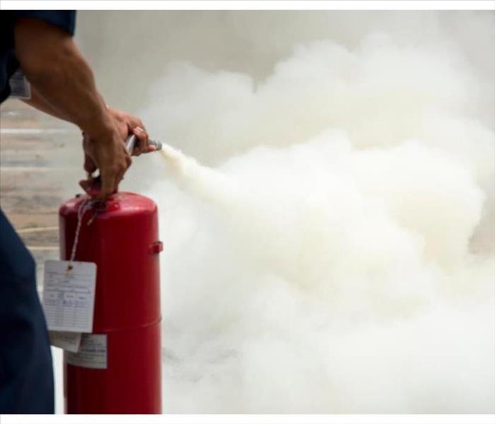 a man practicing the use of a fire extinguisher